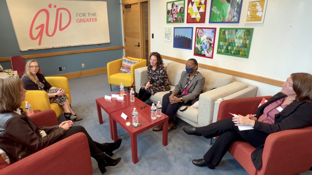 Five people seating around a table have a discussion